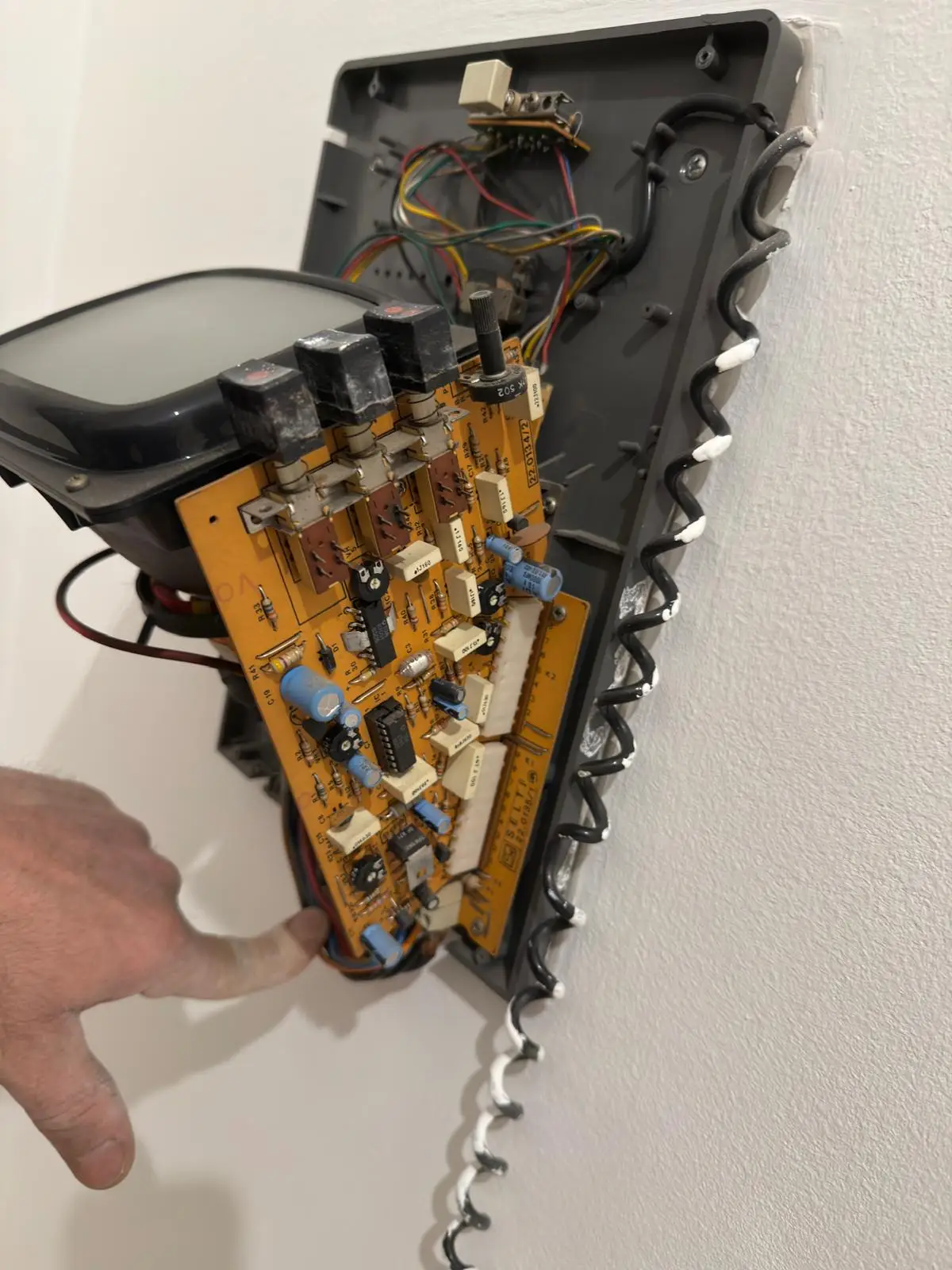 Elettronica interna di un vecchio citofono durante una verifica